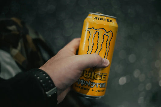 Person holding a Monster Energy can. Photo by Jonathan Cooper on Unsplash.