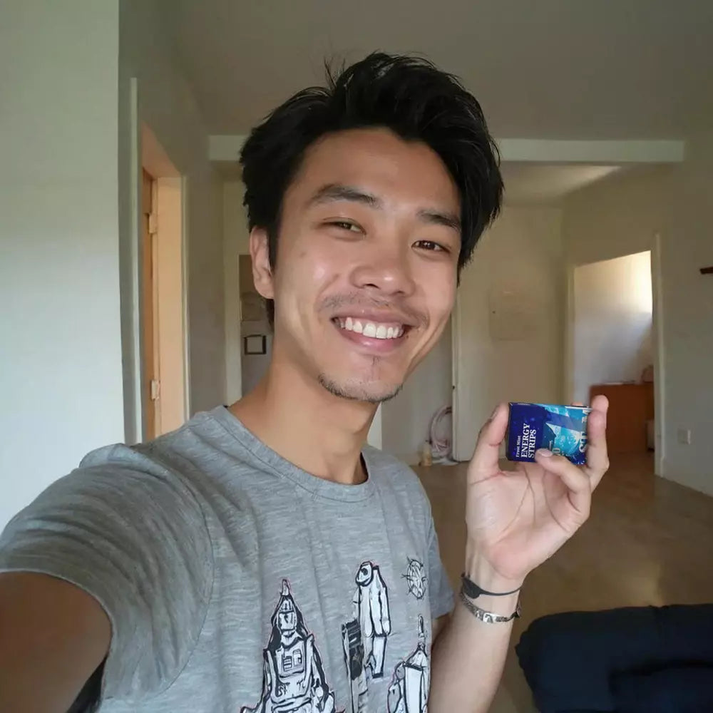 Image of a man holding a STIM Frost Mint pack at home